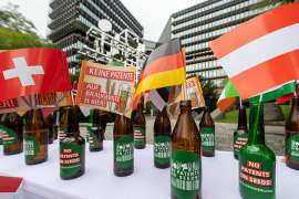Vor dem EPA in Mnchen stehen auf einem Tisch leere Bierflaschen mit Fahnen und Protestbannern gegen die Bierpatente