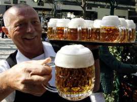 Ein Ober im Schweizerhaus serviert Bier