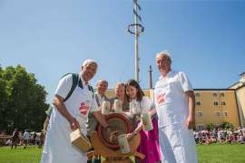 Beim Fassanstich im Bild v.l.: „Moar“ Bartl Gsenger, Stiegl-Chefbraumeister Christian Pöpperl, Stiegl-Eigentümer Heinrich Dieter und Alessandra Kiener. Im Hintergrund die Grödiger Schützenkompanie, die den tonnenschweren Maibaum aufstellte.