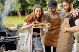Drei junge Leute beim Grillen