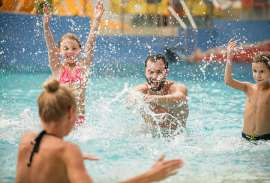 Eine Familie im Schwimmbad hat Spass, es wird gespritzt