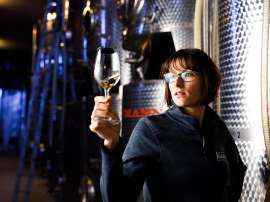 BIO-Winzerin Monika Neustifter im Keller mit einem Glas Rotwein