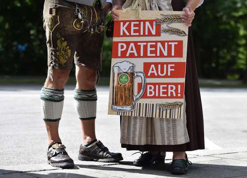 Protestierende in Tracht sind vom Bauch abwrts im Bild, davor ein Protestbanner 'Kein Patent auf Bier'
