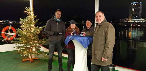 Vor einen Christbaum stehen mehrere Leute auf der MS Kaiserin Elisabeth am Freideck