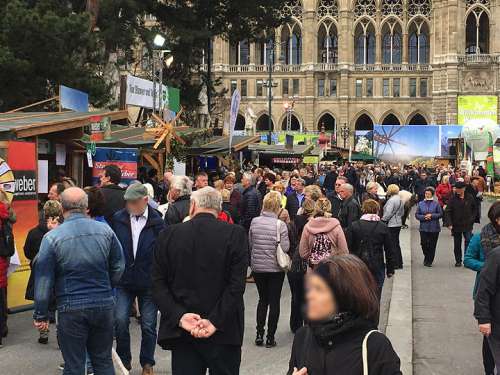 Eine große Menschenmenge drängt sich zwischend den Hütten vor dem Rathaus