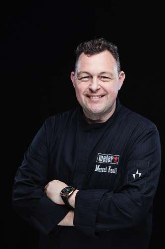 Grillmeister Marcel Ksoll in schwarzer Kochjacke
