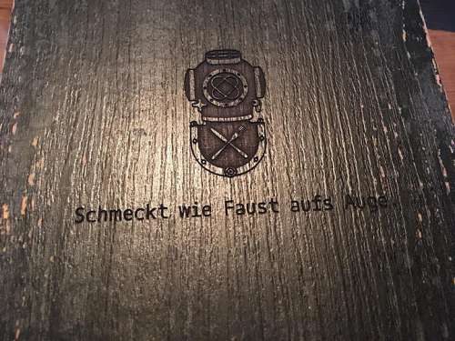 Die Speisekarte mit dem Taucherlogo und dem Motto 'Passt wie Faust aufs Auge'