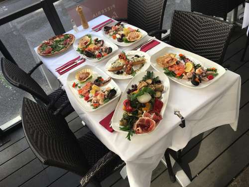 Verschiedene Köstlichkeiten aus der Speisekarte sind auf einem Tisch im Aussenbereich aufgestellt