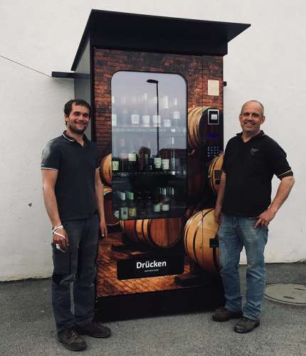 Zwei Winzer präsentieren stolz den Weinautomaten zu Gumpoldskirchen