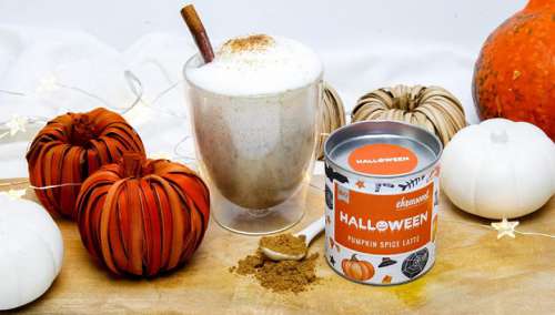 Ein Glas Pumpkin Latte und eine Dose BIO Halloween Pumpkin Spice Latte umgeben von Kürbissen