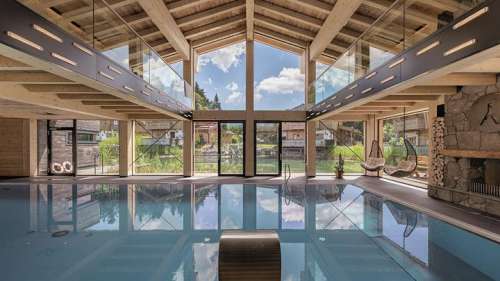 Indoorpool mit Panorama-Lounge im Sommer