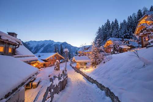 Verschneiter Pfad durch das Chaletdorf