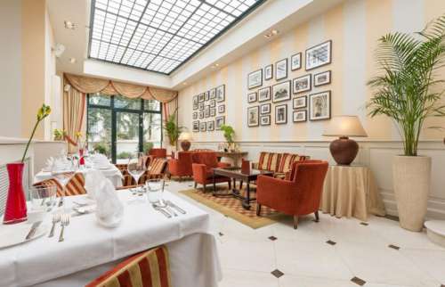 Wintergarten mit gedeckten Tischen im Hotel KAISERHOF Wien