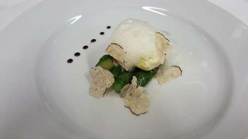 Ein pochiertes Ei von Paolo Parisi auf grünem Spargel, gekrönt mit gehobeltem Trüffel