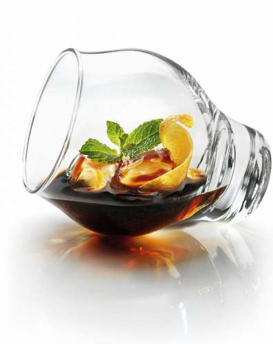 Liegendes Glas entsprechend dem beschriebenen Ritual mit Eis, Averna, Kräutern und Zitruszesten befüllt