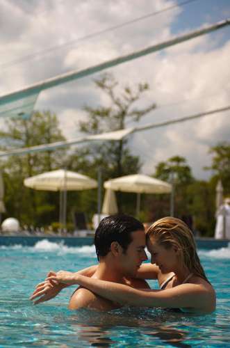 Ein Junges Paar umarmt sich im Aussenpool
