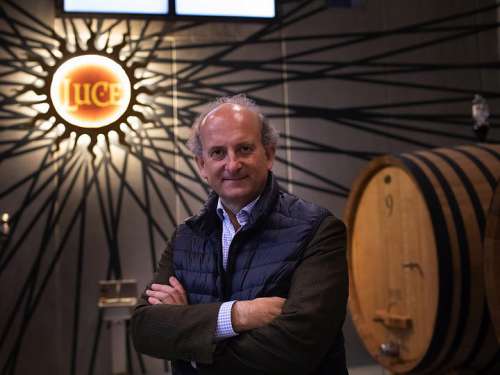 Marchese Lamberto Frescobaldi im Weinkeller, hinter ihm rechts ein Eichenfass, links das imposante Luce-logo